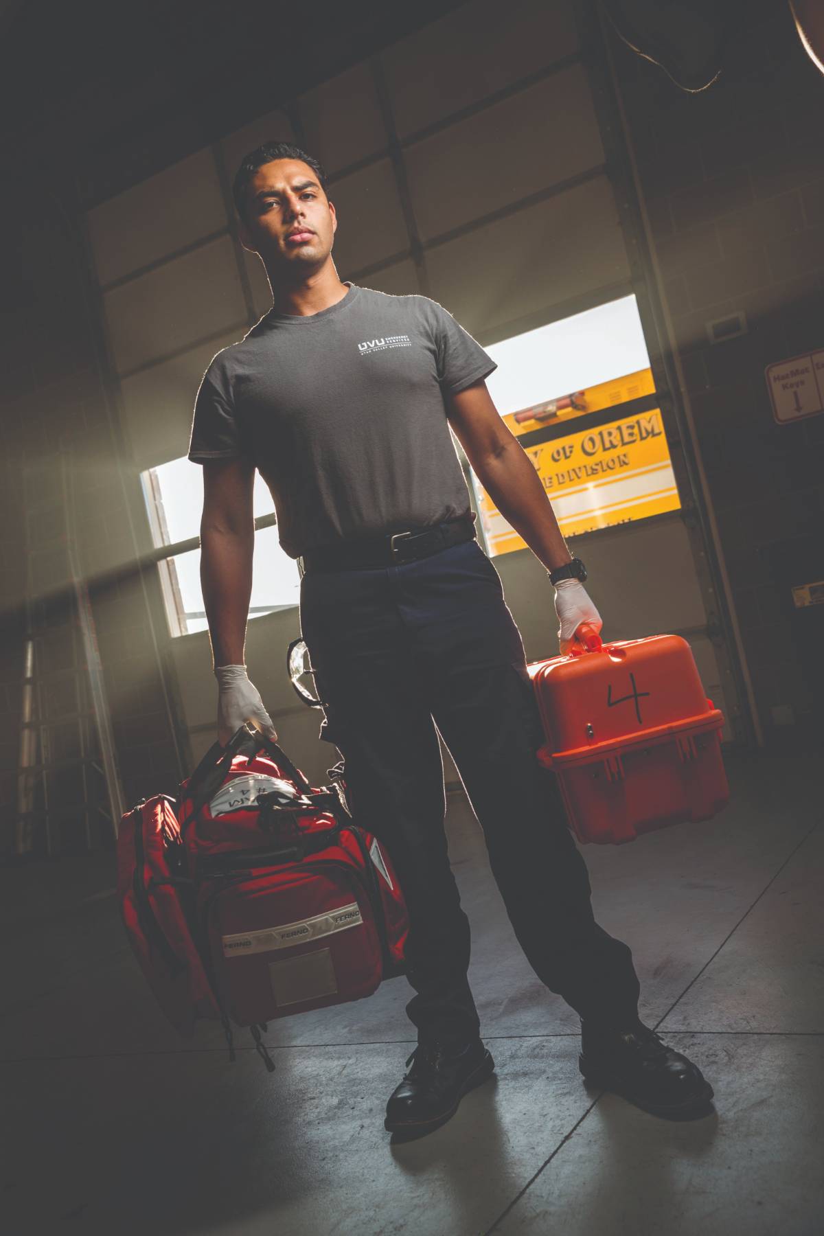 Paramedic standing, holding emergency medical equipment