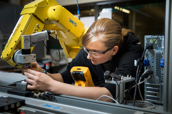 a girl working on a robotic arm