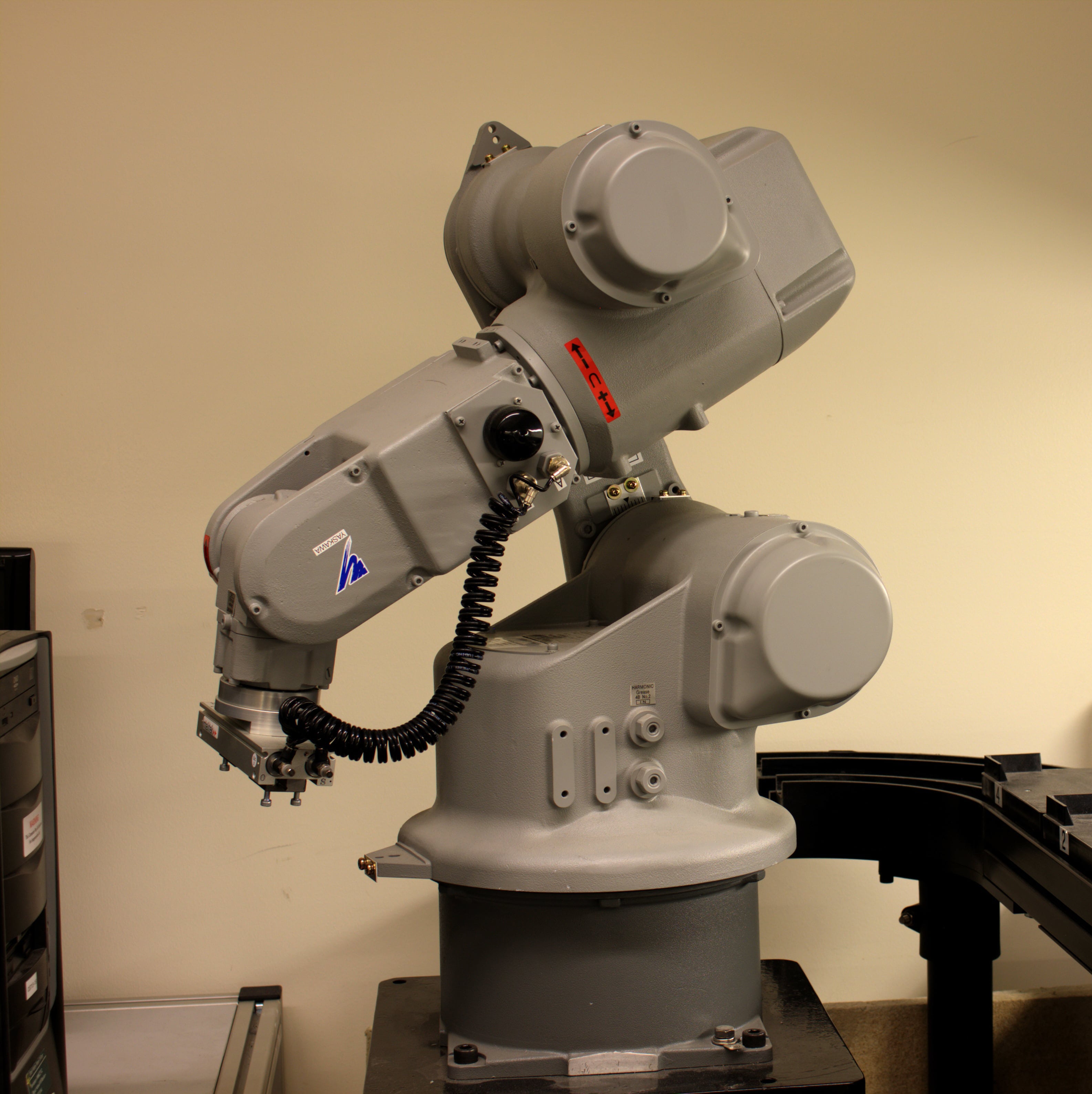 A grey robotic arm in a classroom