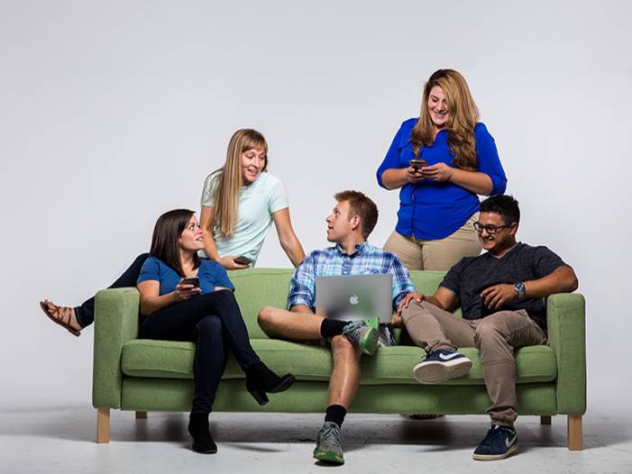 group of students working together sitting on couch