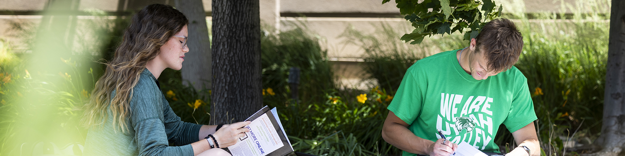 Male and Female student sitting outside studying