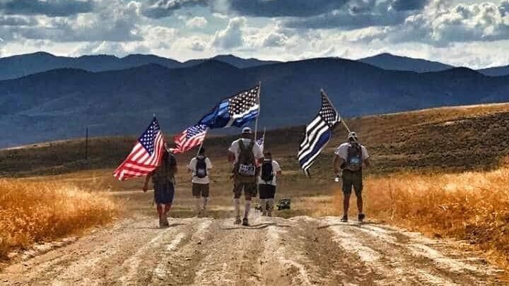 Veterans carrying flags on a hike.