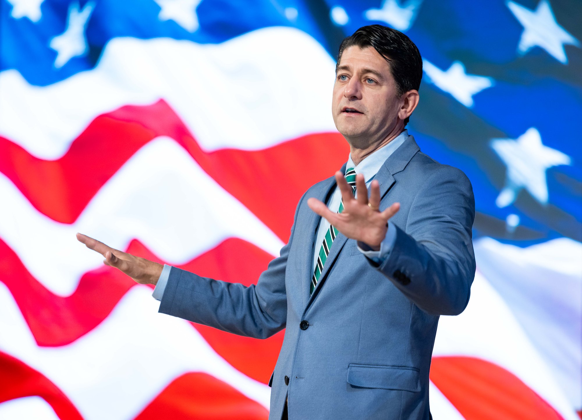 Paul Ryan on stage at UVU with a US Flag background