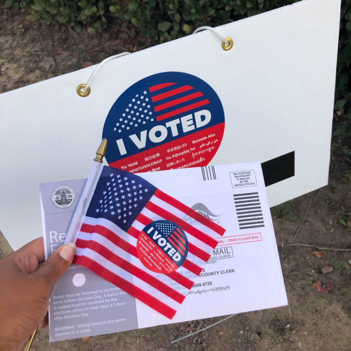 A hand holding a ballot preparing to vote.