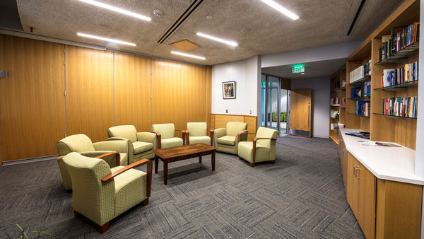 A picture of the convening room inside UVU's Reflection Center. An open room with arm chairs and bookshelves full of books.