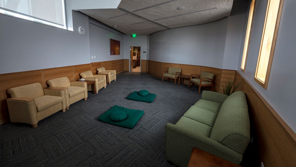 The prayer room inside the Reflection Center at UVU, an open room with arm chairs, a sofa and floor cushions