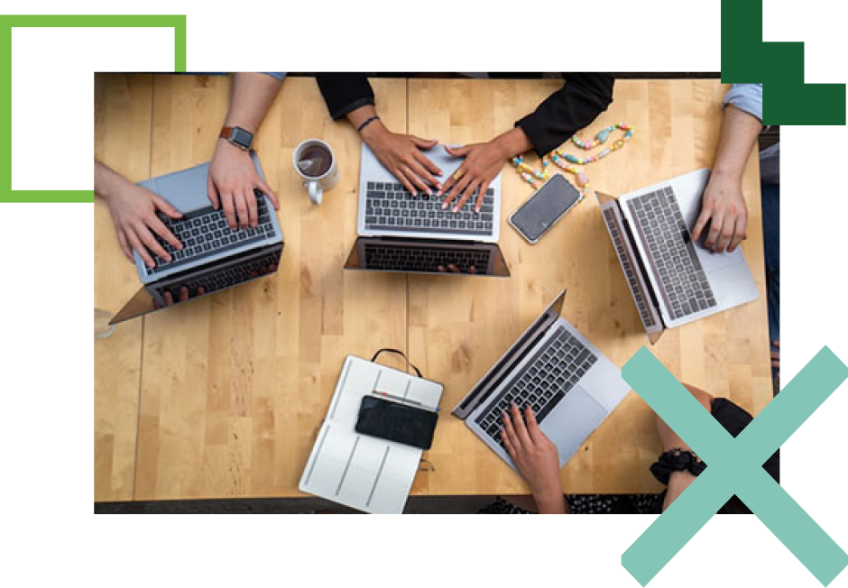 overhead shot of people seated at a table with laptops