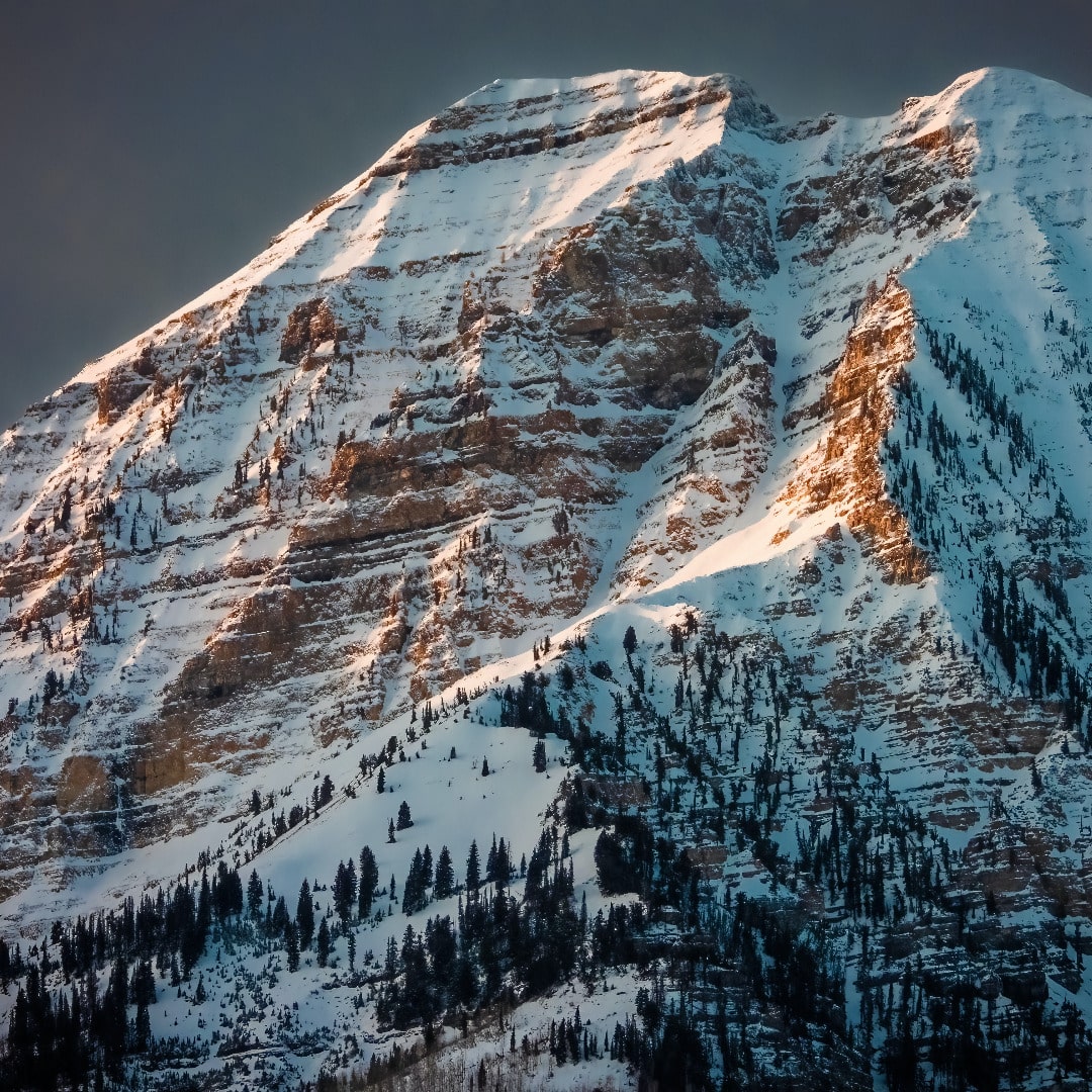 Close-up of peak of Mount Timpanogos covered in snow with alpenglow.