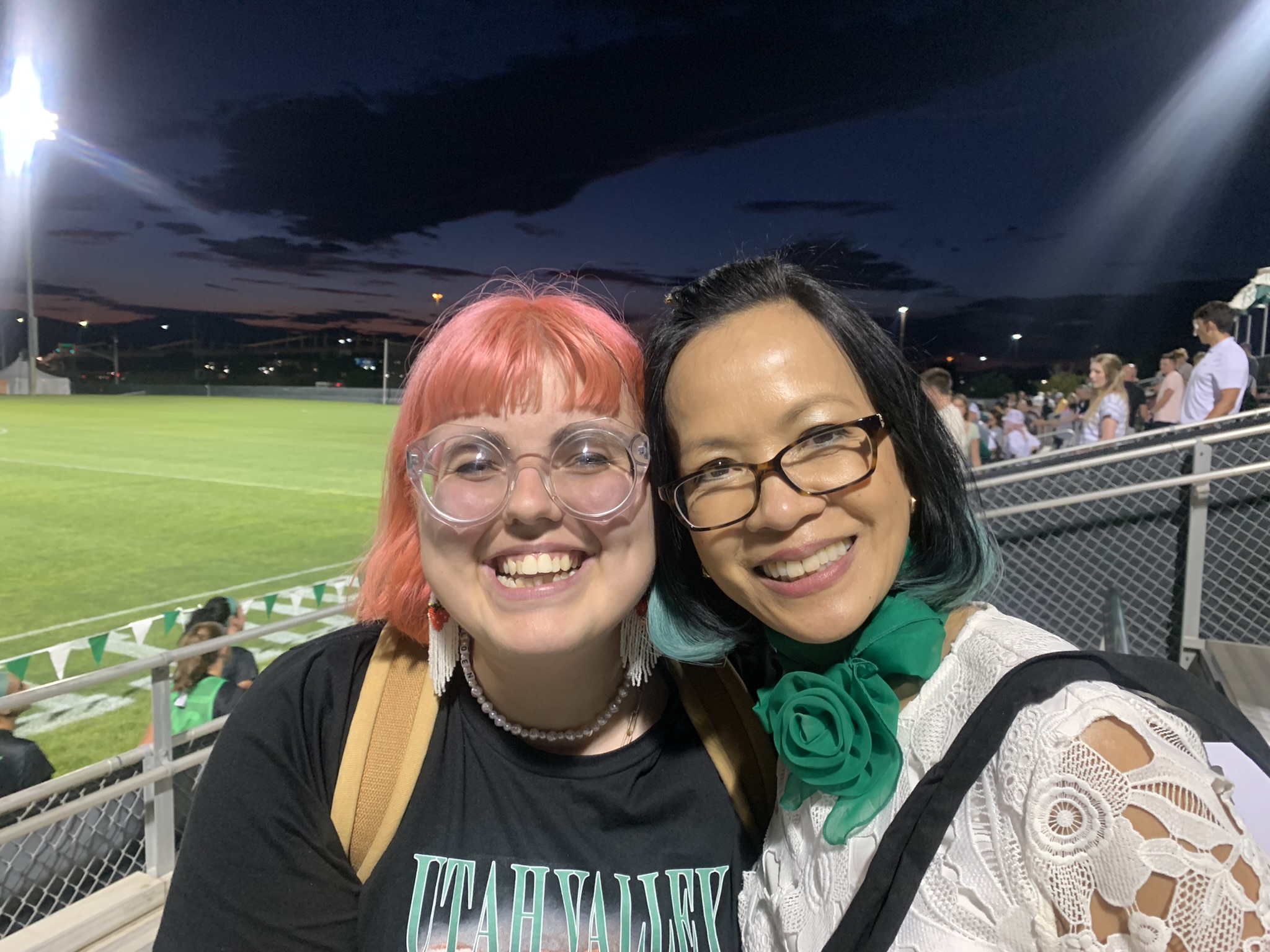 Veronica Clark smiling with President Tuminez at a sports game