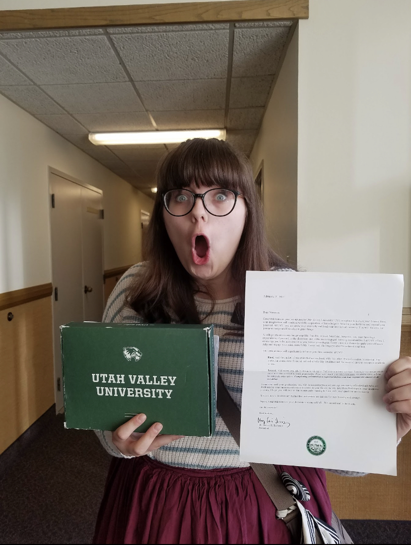 Veronica Clark holding a UVU branded box and acceptance letter