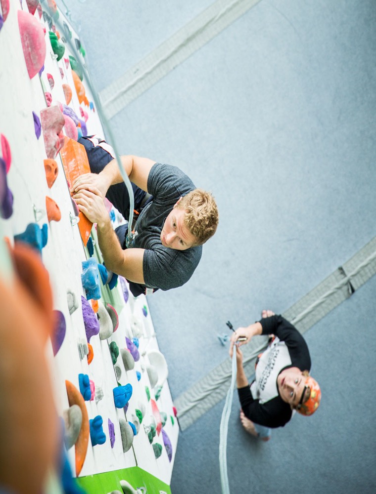 Person on an indoor rock wall lead climbing