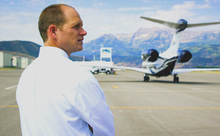 Person standing in foreground with small airplane in the background.