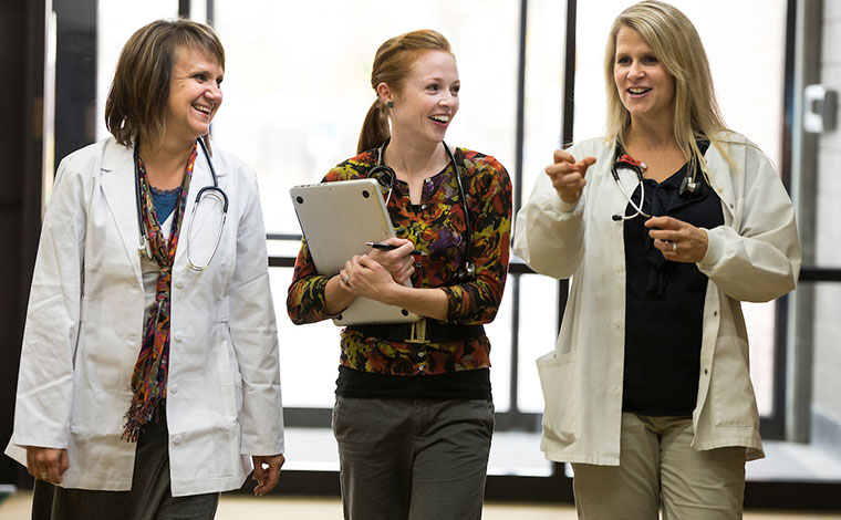 Group of women wearing lab coats and stethoscopes.