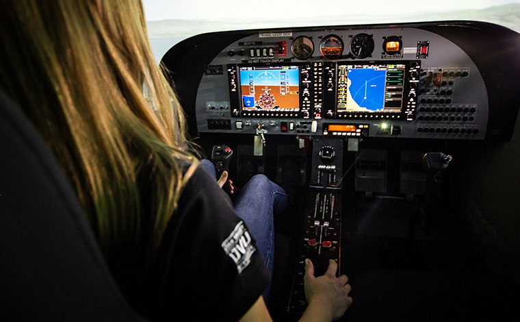 Woman sitting in plane cockpit.