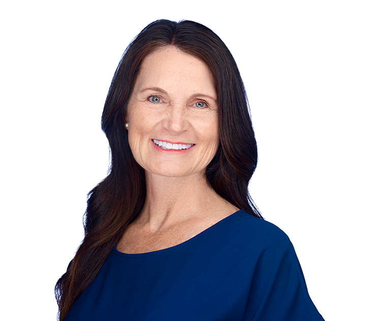 a woman in a blue blouse smiling at the camera