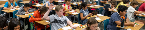 A UVU PREP student raising his hand in a class to ask a question