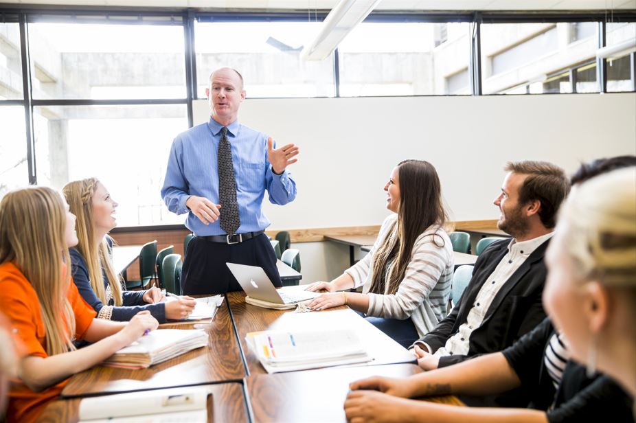 man meets with stakeholders at a conference table