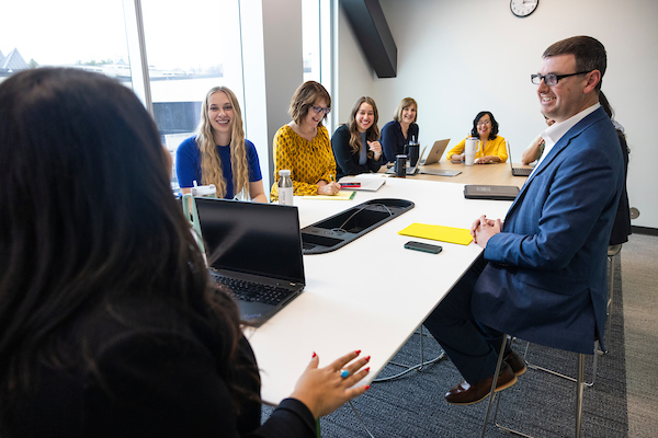 Eight employees sitting around a conference table having a discussion.