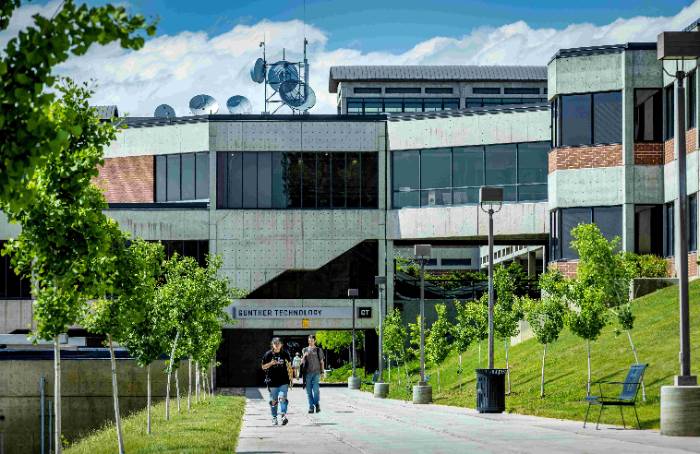 Outside of the GT building with a student walking