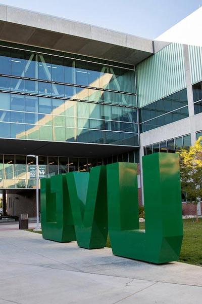 Big green UVU letters sign on UVU campus.