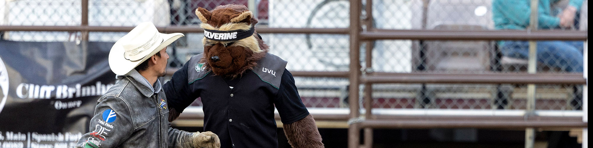 UVU Rodeo college athlete talking to the UVU mascot, Willie the Wolverine