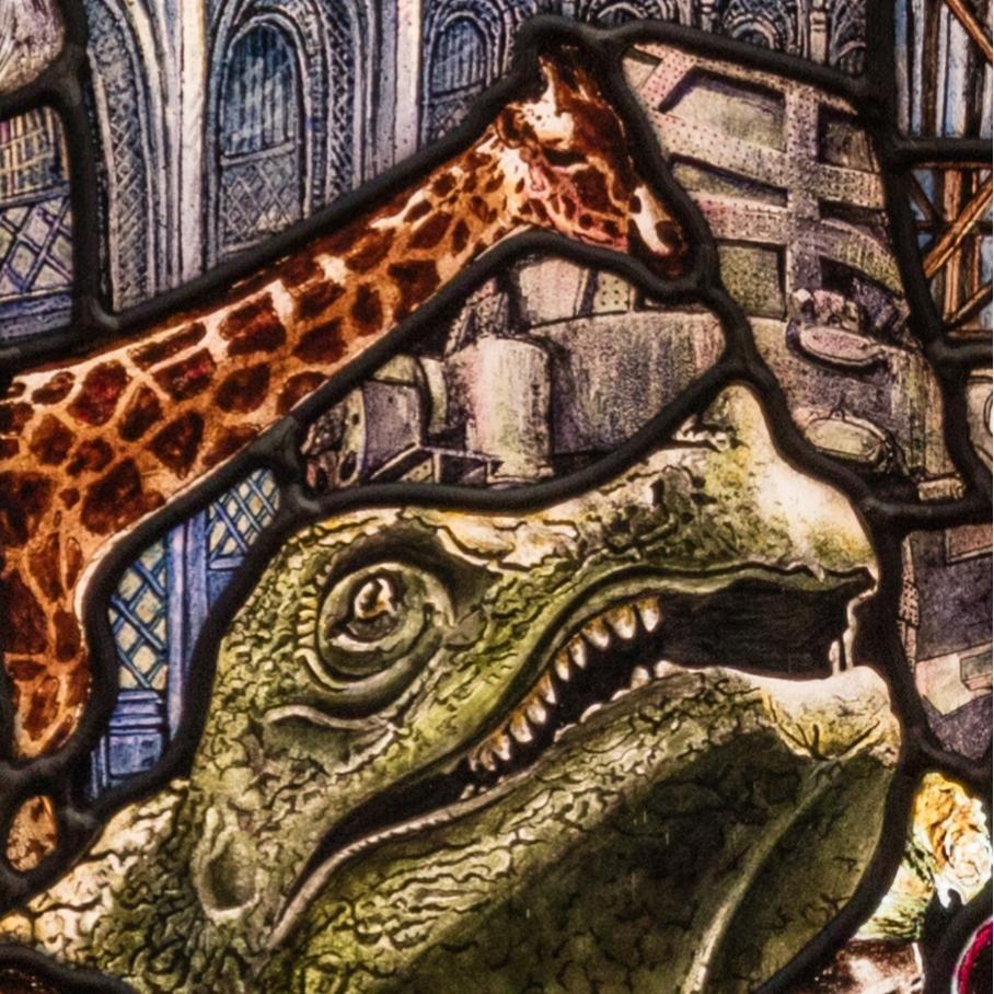 Stained glass showing a giraffe and a dinosaur.