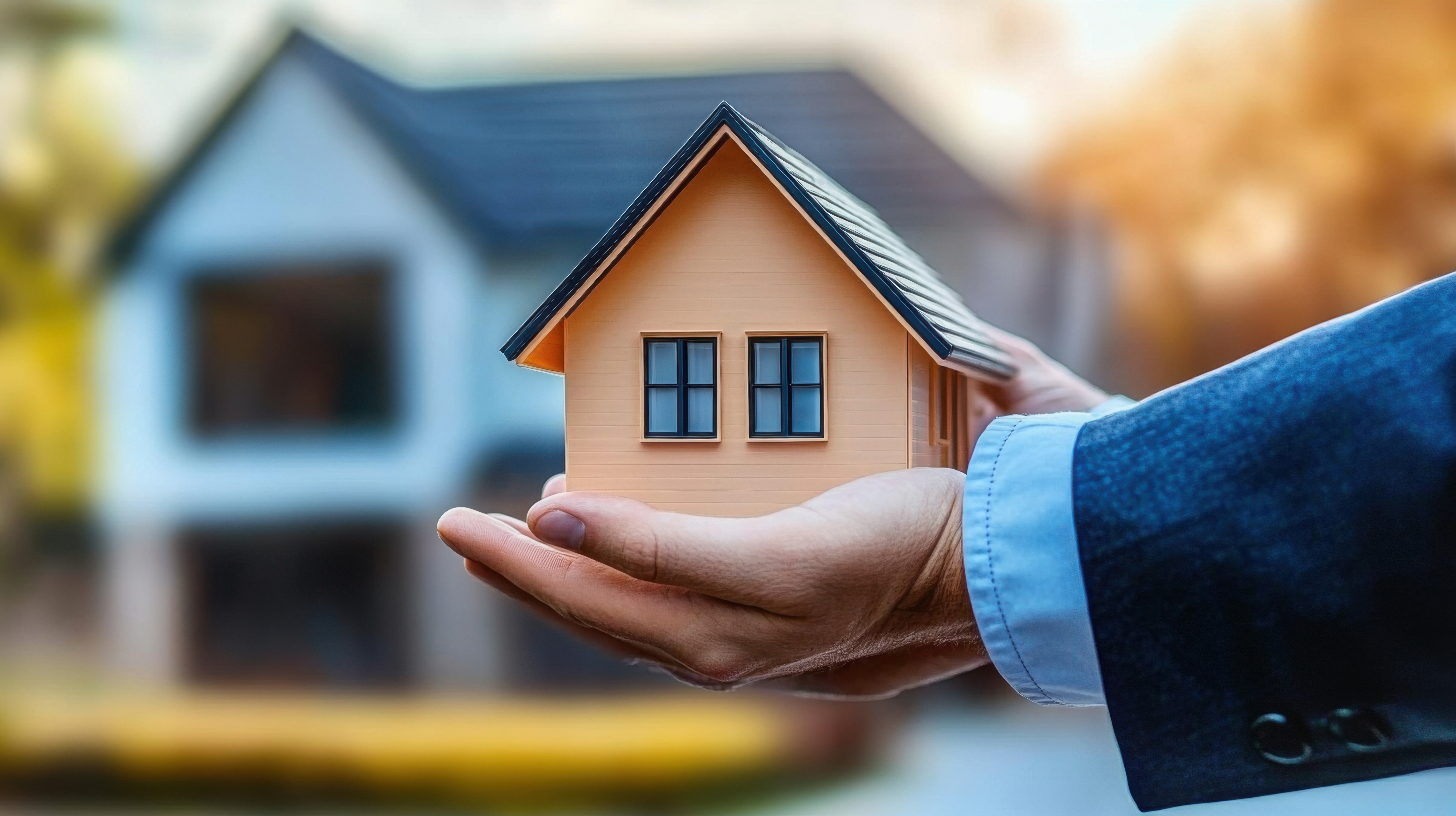 A tiny house held in caring hands