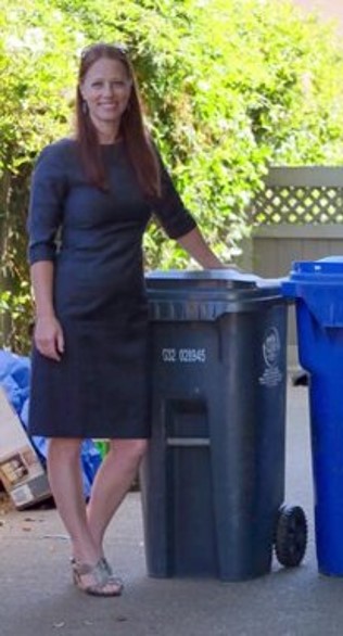 Woman standing next to garbage bin and recycling bin