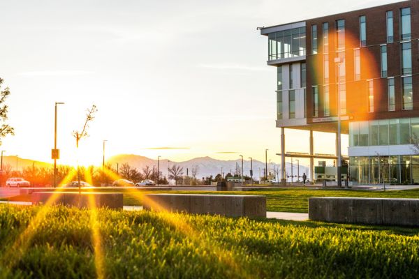 Setting sun shining on UVU's Clarke Building and nearby grassy field