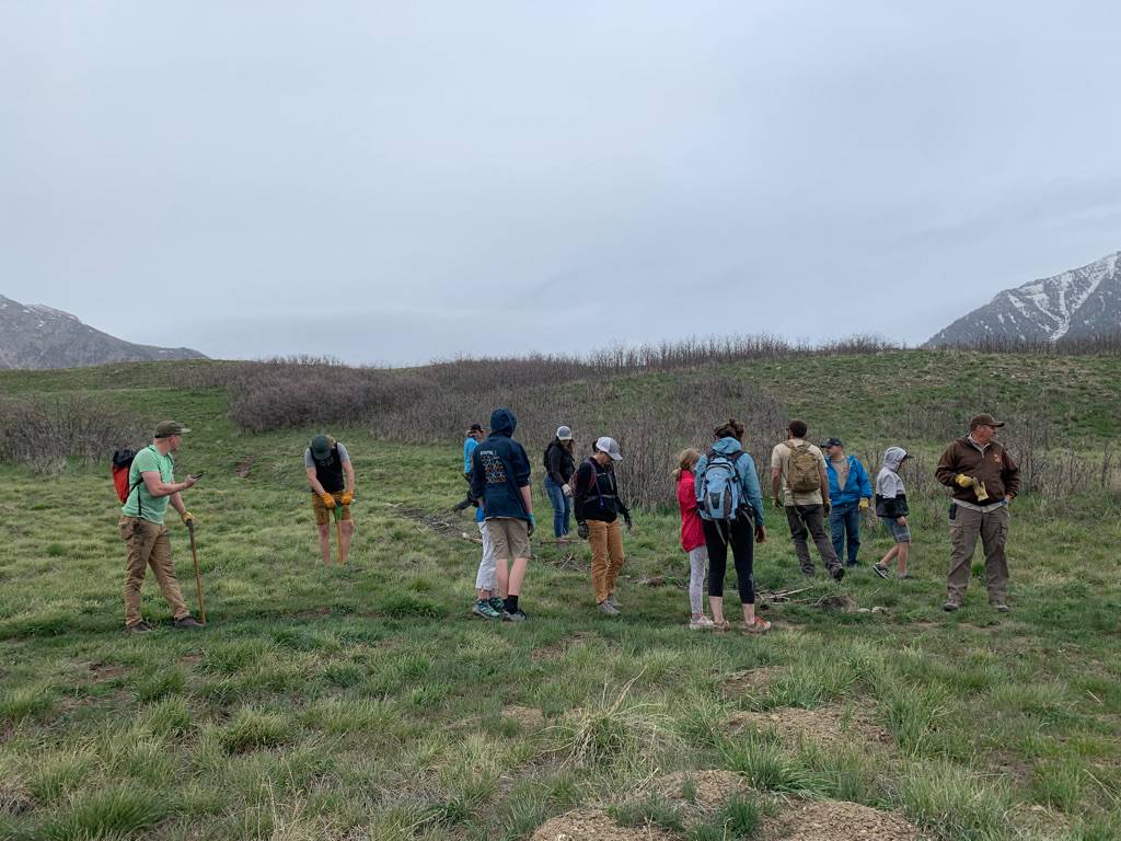 people gathered at a trail to perform trail work