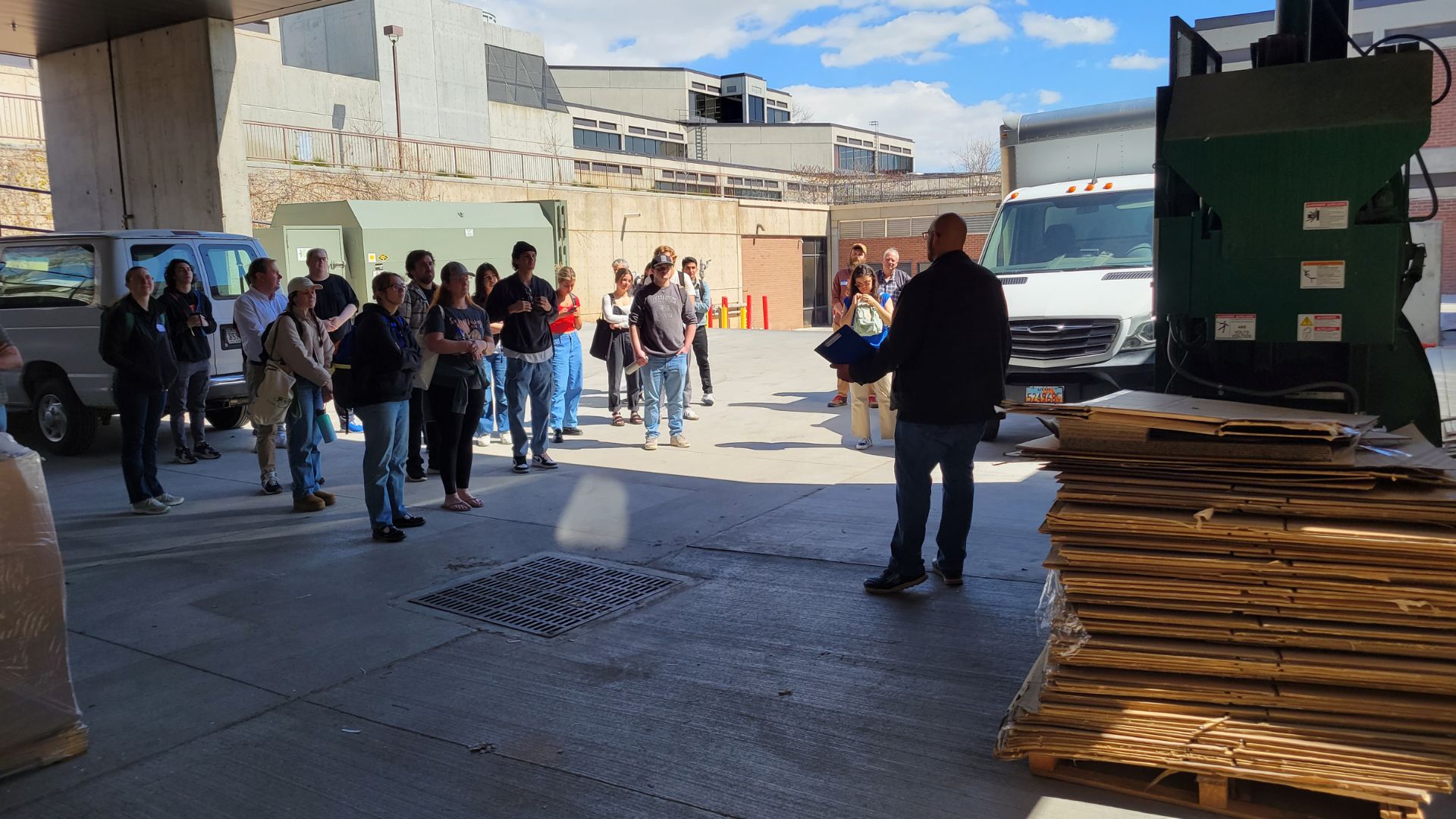 A group of people at the UVU recycling baler