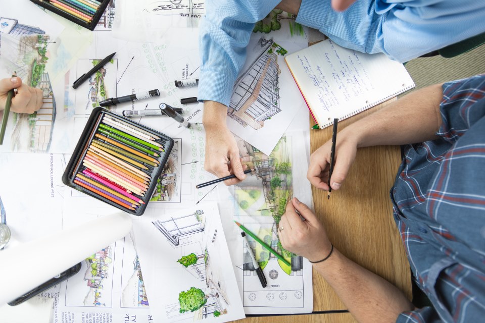 Two people coloring a picture while sitting at a desk