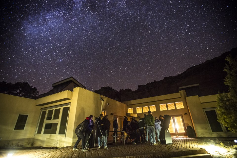 Group of people looking at the stars in a night time sky