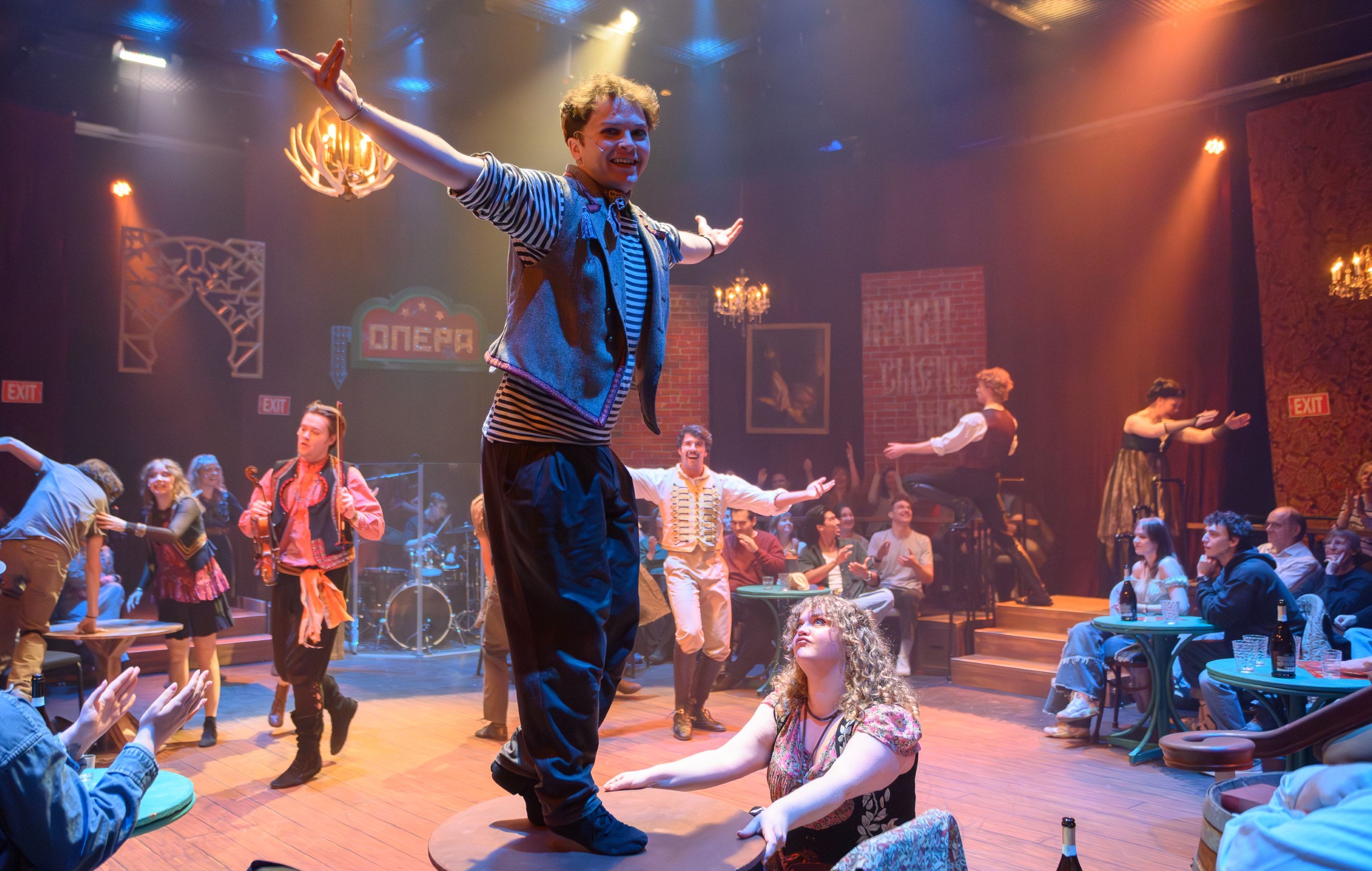 Natasha, Pierre, and the Great Comet of 1812 performance Actors dancing wilding on tables and amid the audience in a smoky arena stage