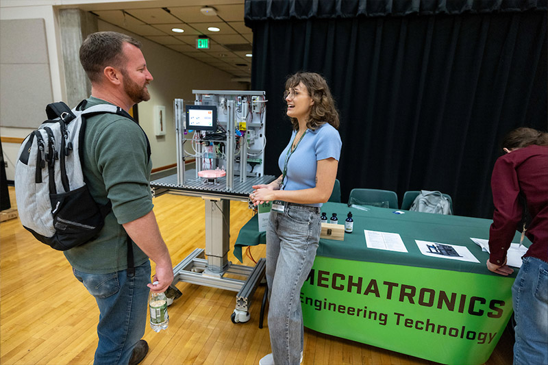 Two people talking at a display table