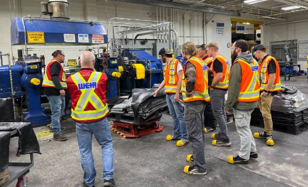 Group of people wearing safety vests in factory