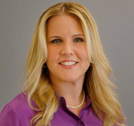 Photo of Melissa Loble  a caucasian female with long blonde hair wearing a purple blouse and pearl necklace