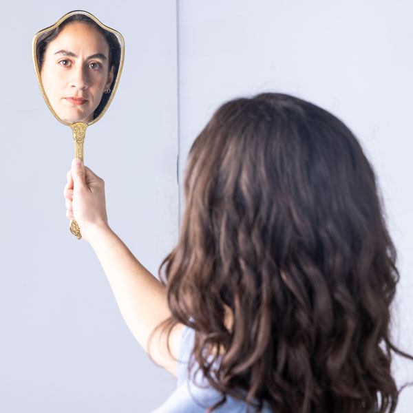 A UVU student looking in a mirror for body acceptance
