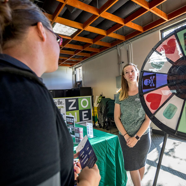 Student interacting with a  UVU Health Programs display