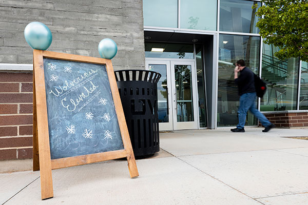 WE Openhouse, someone walking into the building, with signage out front